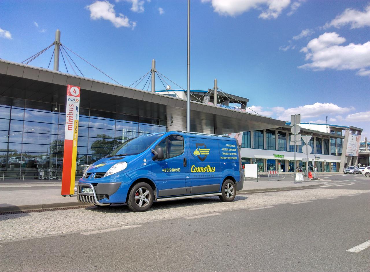 Niebieski bus Cosmo Bus z numerem telefonu na tle terminalu lotniska, z widocznym znakiem 'minibus peri>>' i fragmentem parkingu.