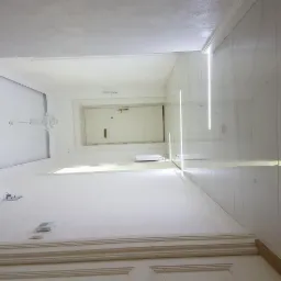 Wnętrze korytarza z marmurowymi ścianami, oświetleniem LED w pionowych liniach, kryształowym żyrandolem i białymi drzwiami wejściowymi, widziane z dołu pod kątem.