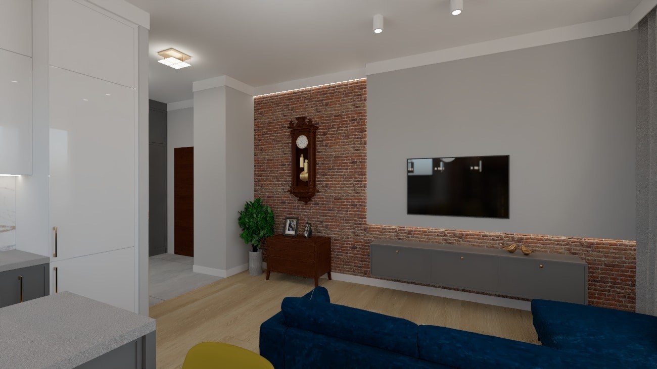 Wizualizacja salonu z ceglaną ścianą, drewnianym zegarem i niebieską sofą, widok na aneks kuchenny z szarymi blatami i białymi szafkami.