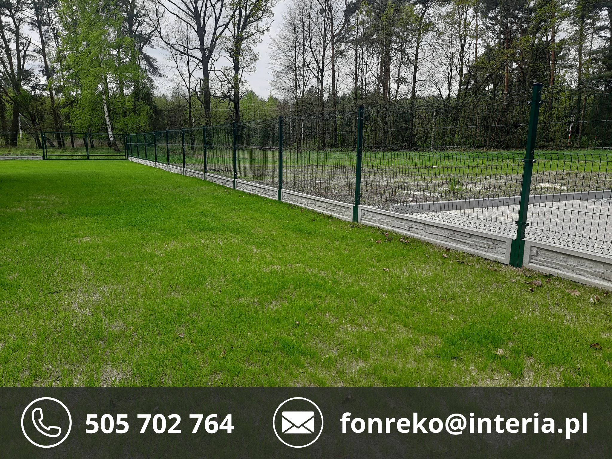 Zielone ogrodzenie panelowe z podmurówką na tle trawnika i drzew. Widoczne słupki i siatka ogrodzeniowa. Zastosowano betonową podmurówkę.