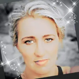 Portret kobiety z krótkimi, blond włosami i jasnymi oczami, wzbogacony o cyfrowe efekty specjalne w postaci błyszczących gwiazdek. Twarz na rozmytym, szaro-białym tle.