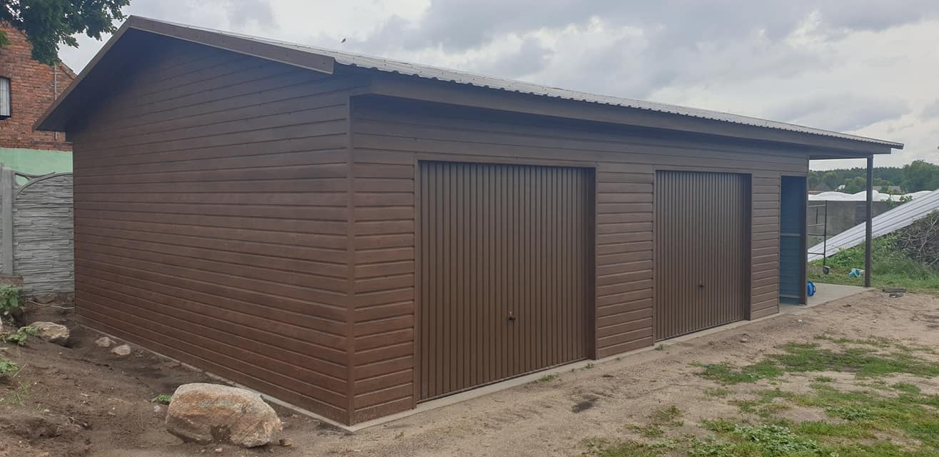 Gotowy, dwustanowiskowy garaż blaszany z brązową elewacją imitującą drewno, widok z zewnątrz na tle pochmurnego nieba.