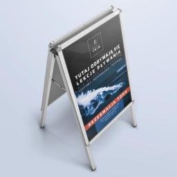 Designers Agencja Multimedialna K. Malinowski - Stojak reklamowy z plakatem informującym o lekcjach pływania dla dzieci i dorosłych, z logo Adrianna Swim i informacją o rezerwacji toru.