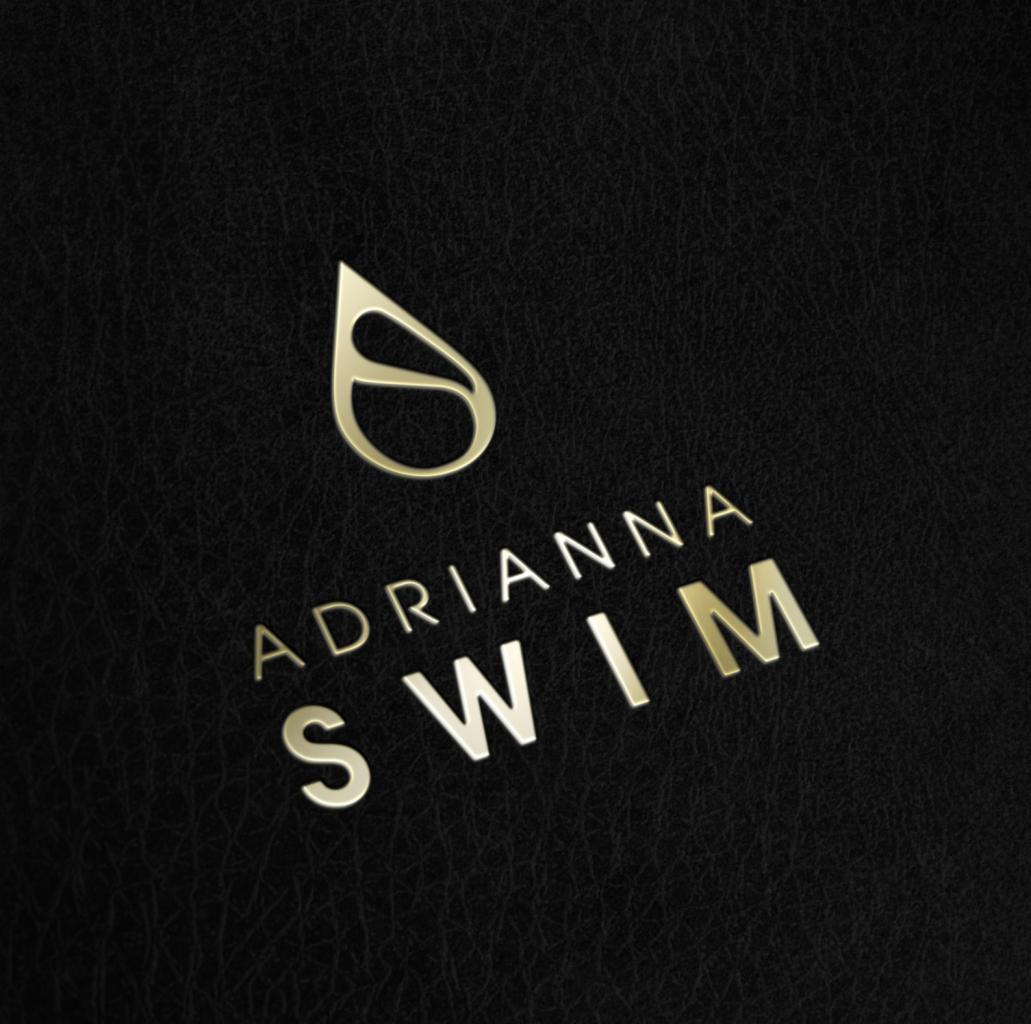 Złote logo 'Adrianna Swim' z symbolem kropli na czarnym teksturowanym tle.