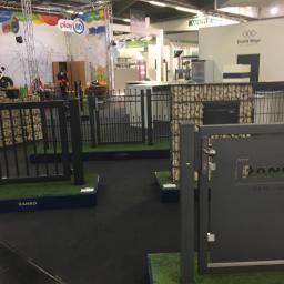 PPUH Nastała Lucjan - Ekspozycja różnych modeli ogrodzeń i bram firmy Ranko na targach, z widocznymi elementami z gabionów i sztucznej trawy, w tle stoisko Play 8D.