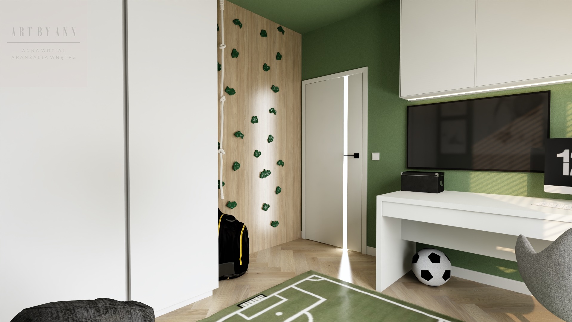 Pokój dziecięcy z zielonymi ścianami, ścianką wspinaczkową i biurkiem. Na podłodze dywan w kształcie boiska. Widoczny fragment logotypu projektanta.