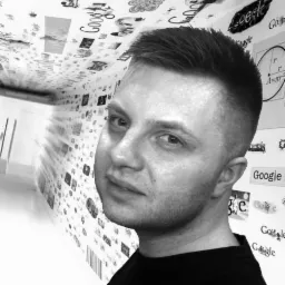 Mężczyzna z krótkimi włosami, na tle ściany z nadrukowanymi logotypami Google i wzorami, czarno-białe zdjęcie.