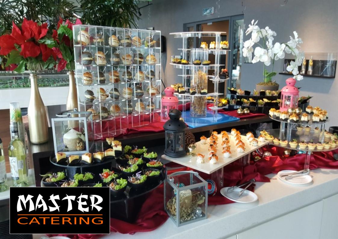 Elegancki stół cateringowy z różnorodnymi przekąskami, w tym mini-burgerami w akrylowym stojaku, sushi z kawiorem, tartaletkami i sałatkami w czarnych miseczkach, udekorowany kwiatami i lampionami,...