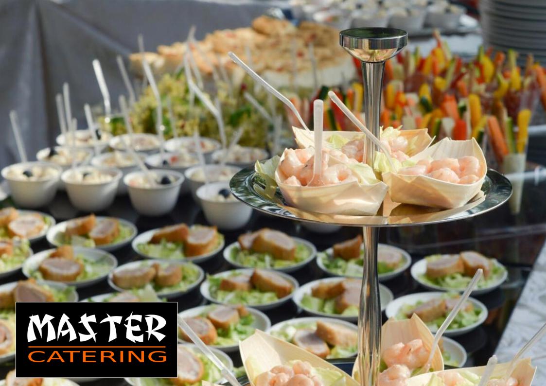 Elegancki stół z przekąskami: krewetki w łódeczkach z sałaty na srebrnym stojaku, mini-sałatki w białych miseczkach, koreczki warzywne i inne przystawki. Widoczne logo firmy cateringowej.