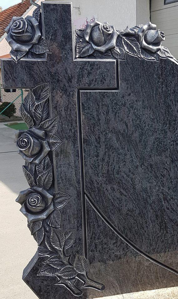 Granitowy nagrobek z krzyżem i płaskorzeźbami róż, widok z boku.