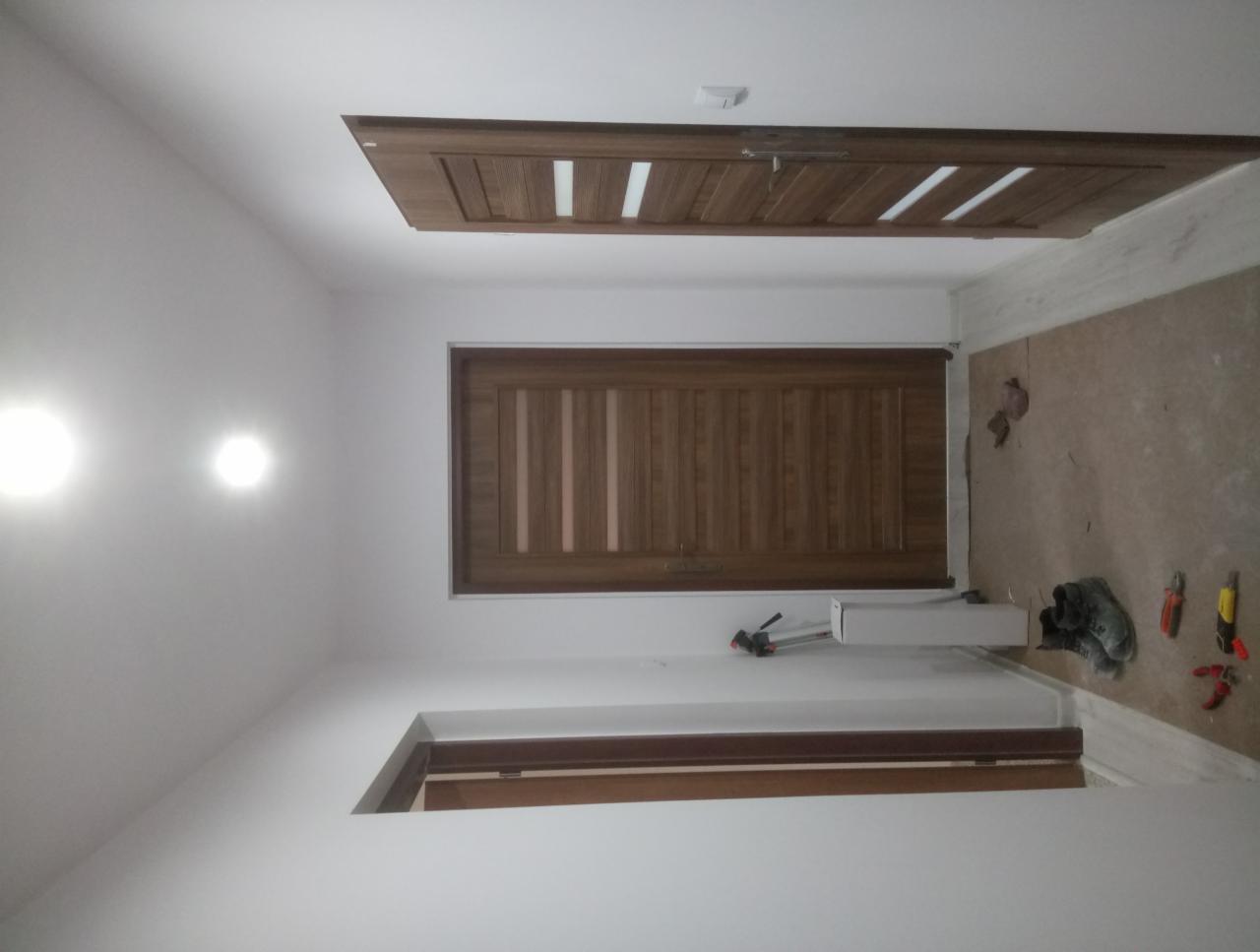 Adaptacja poddasza we Wschowie: widok na wykończone drewniane panele ścienne i sufitowe, z widocznymi narzędziami i materiałami budowlanymi na podłodze.