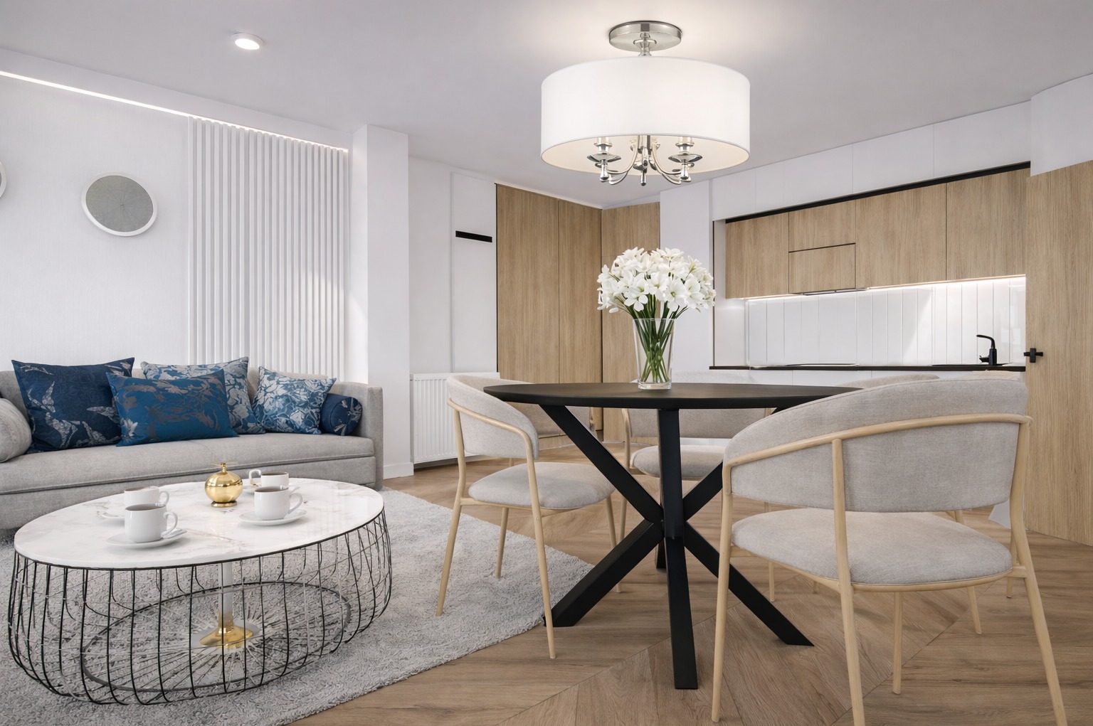 Jasne wnętrze z sofą, stolikiem kawowym i okrągłym stołem jadalnym z kwiatami. Minimalistyczny design, drewniane akcenty i nowoczesne oświetlenie.