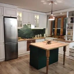 Kuchnia w stylu angielskim. Dodatkowo wyspa w kolorze zielonym z możliwością wykorzystania jej jako stół