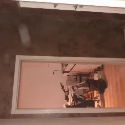 Ukończona podłoga z ciemnych, brązowych płytek w przejściu, widok z góry, zarys białej futryny drzwi.