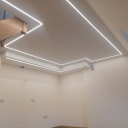 Firma REMONTOWO-BUDOWLANA Piotr Soltys - Nowoczesne oświetlenie sufitowe LED w kształcie kwadratu, z drewnianym elementem konstrukcyjnym. Jasne, minimalistyczne wnętrze w trakcie wykańczania.