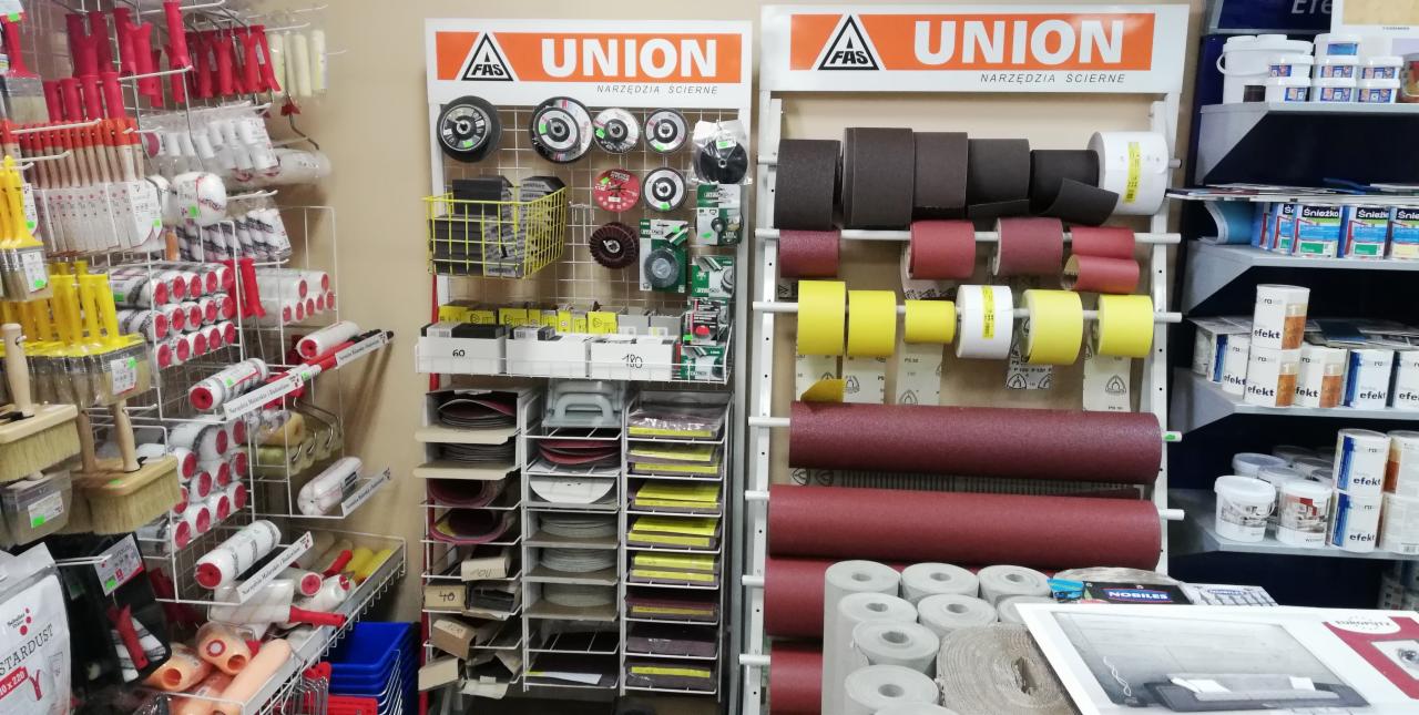 Ekspozycja narzędzi ściernych marki Union w sklepie budowlanym w Nowym Targu: tarcze, papiery ścierne w rolkach i arkuszach, pędzle i wałki malarskie.