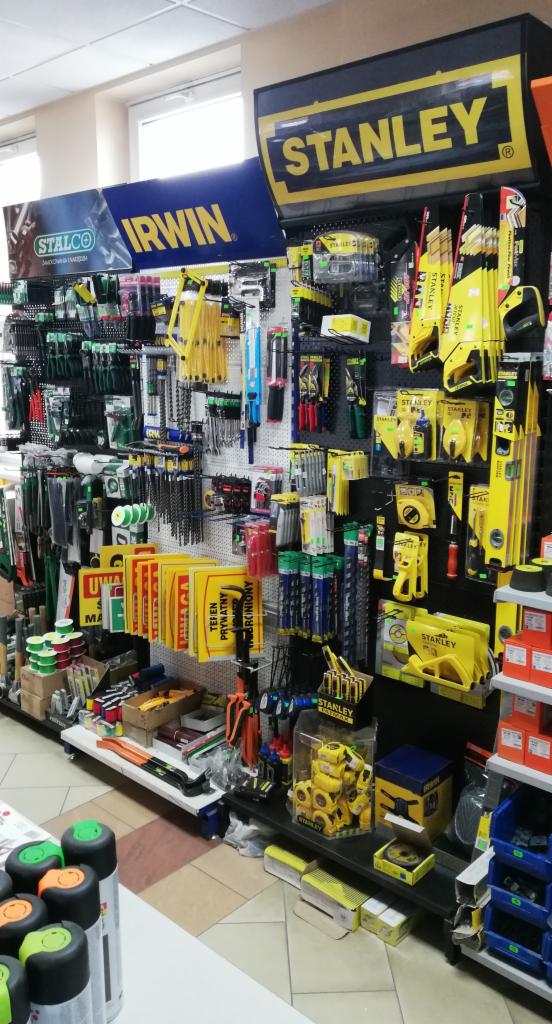 Ekspozycja narzędzi budowlanych marek Stanley, Irwin i Stalco w sklepie, widoczne różnorodne narzędzia ręczne i akcesoria budowlane.