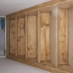 Konstrukcja szkieletowa z drewna, prawdopodobnie pod zabudowę płytami kartonowo-gipsowymi, widoczne fragmenty izolacji i szpachlowania.