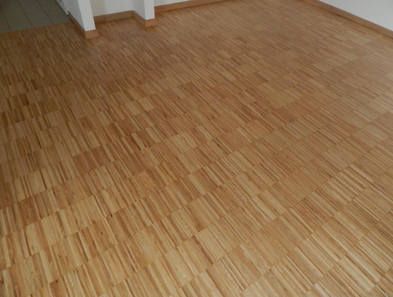 Parkiet ułożony w jodełkę, wykończony listwami przypodłogowymi, widok z góry.