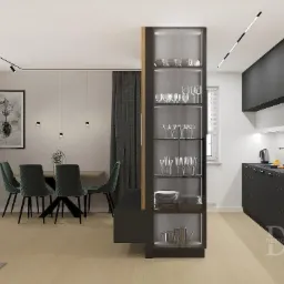 Nowoczesne wnętrze: czarne szafki kuchenne, przeszklona witryna z zastawą, stół z zielonymi krzesłami i minimalistyczne oświetlenie punktowe.