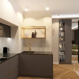 Nowoczesna kuchnia z szarymi szafkami, czarnym blatem, złotą armaturą i półką, marmurowym backsplash'em, widok na salon z zieloną sofą i regał z książkami.
