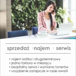 Kobieta w różowej marynarce rozmawia przez telefon i pracuje na laptopie w biurze z zieloną ścianą, obok leżą okulary i książki. Reklama firmy oferującej sprzedaż, wynajem i serwis kopiarek...