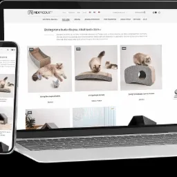 Laptop i smartfon prezentują stronę sklepu internetowego z ekologicznymi budami dla psów i kotów, z widocznymi produktami i cenami. Minimalistyczny design.