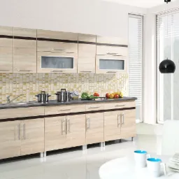 Jasna, nowoczesna kuchnia systemowa z drewnopodobnymi frontami, ciemnymi akcentami i mozaiką nad blatem. Na blacie stoją garnki, warzywa i owoce. W tle widoczne okno z żaluzjami i czarne lampy...