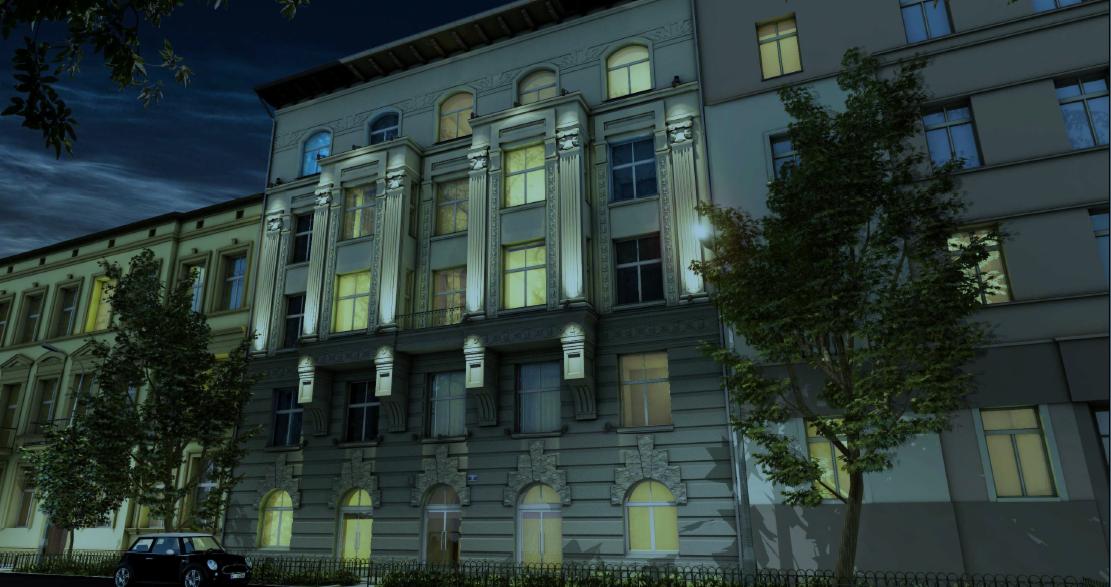 Elewacja kamienicy z oświetlonymi oknami, widok z dołu, z przodu rosną drzewa, a na ulicy stoi czarny Mini Cooper.