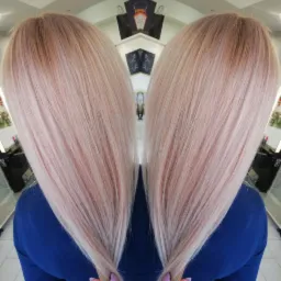 Rozjaśnione, długie włosy w odcieniach blondu i różu, widziane z tyłu, z lekkim efektem lustrzanego odbicia, ukazujące teksturę i kolor włosów.