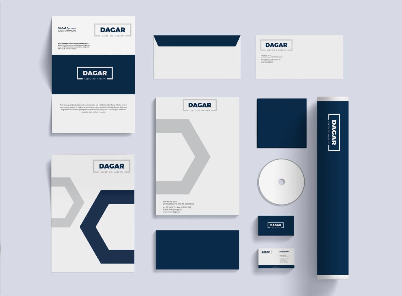 Komplet materiałów identyfikacji wizualnej firmy DAGAR, zawierający papier firmowy, wizytówki, koperty, płytę CD i tubę na dokumenty, utrzymany w kolorystyce bieli i granatu z elementami szarości.