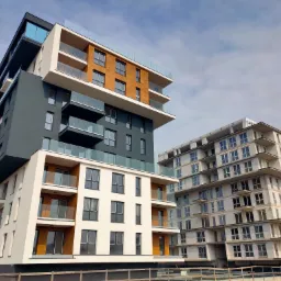 Dwa budynki wielorodzinne: jeden częściowo wykończony z oknami i balkonami, drugi w stanie surowym z widoczną konstrukcją i oknami wstawionymi w większości otworów, Nowa Dąbrowa ul.Graniczna