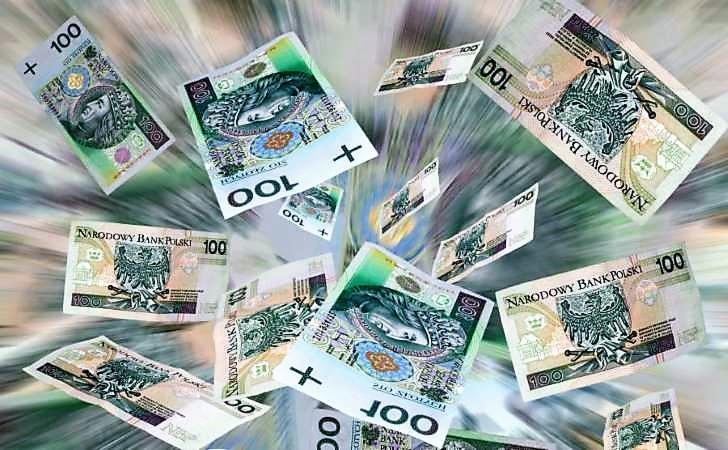 Rozmyte tło z unoszącymi się banknotami 100 złotych, z efektem ruchu i dynamiki.