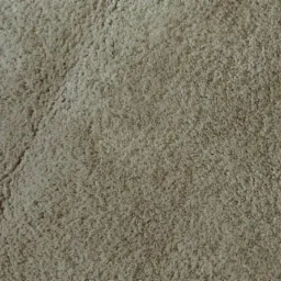 Beżowy dywan z długim, gęstym włosiem, widoczny z bliska, z delikatnym załamaniem światła tworzącym subtelny wzór.