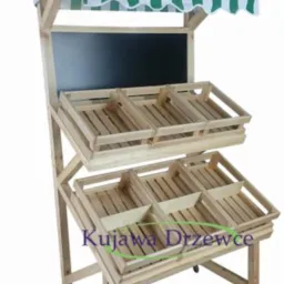 Drewniany regał sklepowy na kółkach z dwoma poziomami skrzynek i tablicą, z daszkiem w zielono-białe paski.