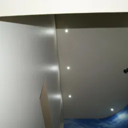 Nowoczesny sufit podwieszany z oświetleniem punktowym LED i fragmentem fototapety z motywem nieba, widok z dołu.