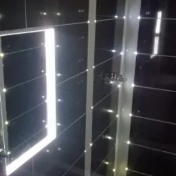 Wykończona łazienka z czarnymi płytkami i białymi fugami, umywalka narożna, bateria jednouchwytowa, oświetlenie punktowe w fugach.