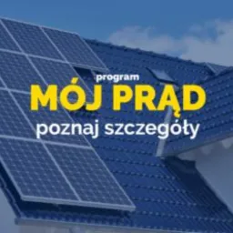 Panele słoneczne na dachu domu jednorodzinnego, widoczny program 'Mój Prąd', błękitne niebo w tle.