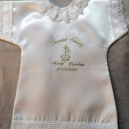 PMu - Biała, satynowa szatka do chrztu z haftowanym imieniem dziecka, datą oraz symbolem kielicha i krzyża, wykończona koronką na dekolcie i dole.