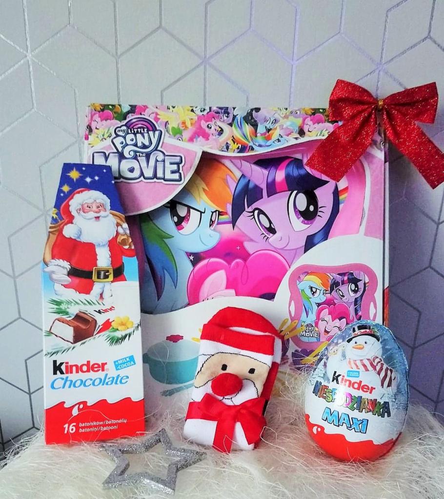 Zestaw upominkowy dla dziecka: pudełko z motywem My Little Pony, czekolada Kinder z Mikołajem, skarpetka z Mikołajem i jajo Kinder Niespodzianka Maxi ze śnieżnym motywem, całość przewiązana...