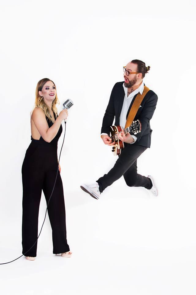 Wokalistka z mikrofonem i gitarzysta w locie na białym tle, prezentacja duetu muzycznego.