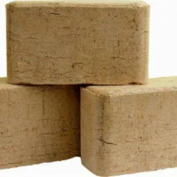 Trzy brykiety drzewne ułożone jeden na drugim, widoczne pęknięcia na powierzchni, jasne tło.