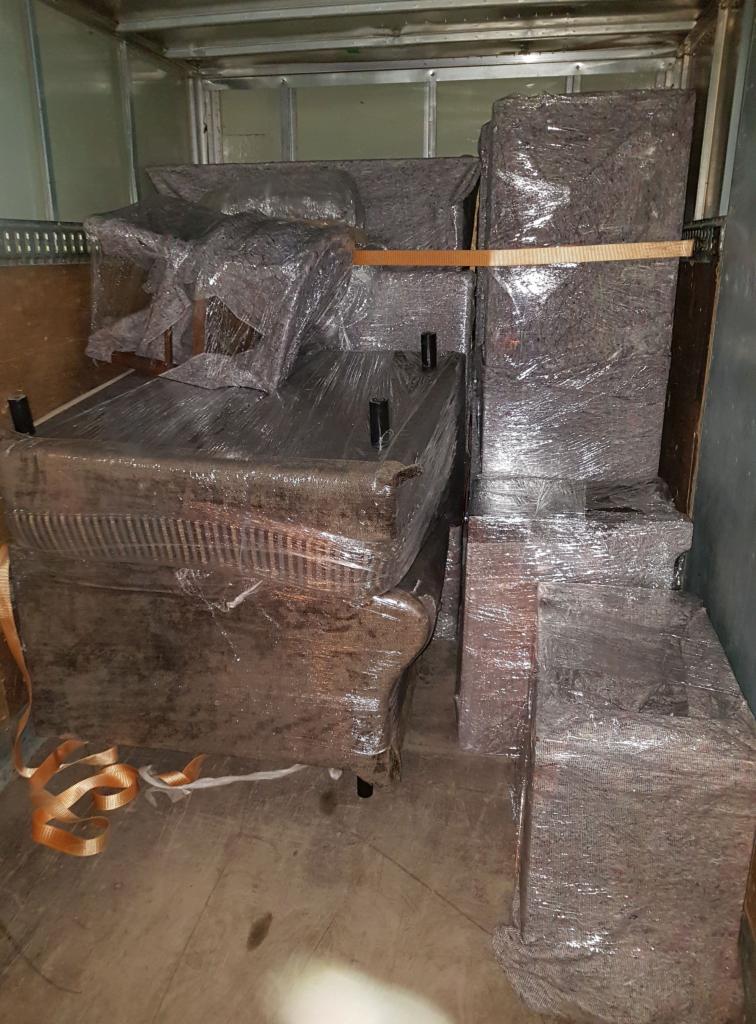 Mebel oklejone folią stretch i zabezpieczone pasami transportowymi wewnątrz przestrzeni ładunkowej busa.