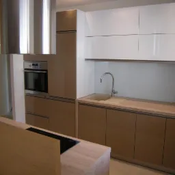 Nowoczesna kuchnia z brązowymi i białymi szafkami, srebrnym okapem nad piekarnikiem i płytą indukcyjną na wyspie kuchennej.