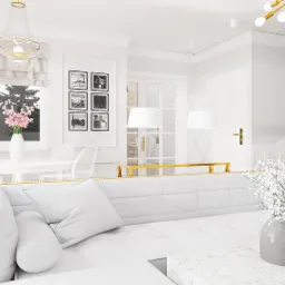 Jasne, przestronne wnętrze z białym narożnikiem z pikowaniem i złotymi detalami, marmurowym stolikiem kawowym, okrągłym stołem z krzesłami i dekoracyjnymi lampami, w tle schody.