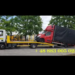 Biało-żółty pojazd pomocy drogowej z czerwonym samochodem dostawczym na platformie, widoczny numer telefonu na zdjęciu.