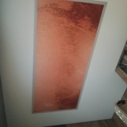 Voytex , Sufity Napinane , Wykonczenia , remonty - Błyszczący, miedziany sufit napinany z efektem ombre, wkomponowany w białą ramę. Widoczny fragment podłogi i ściany. Nietypowy kształt wnęki.