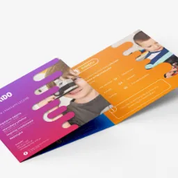 Trzyczęściowa, składana ulotka reklamowa firmy Edukido prezentująca zajęcia z robotyki dla dzieci, widoczne elementy graficzne i tekstowe, w tle uśmiechnięty chłopiec z modelem z klocków LEGO.