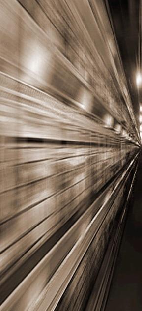 Rozmyte ujęcie metalowej konstrukcji, przypominające wnętrze tunelu lub hali w trakcie budowy, sfotografowane z dynamicznej perspektywy z efektem rozmycia w ruchu.