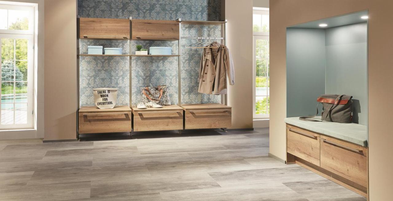 Nowoczesna garderoba z drewnianymi elementami, wnęką z siedziskiem i torbą, oraz dekoracyjną tapetą w tle.